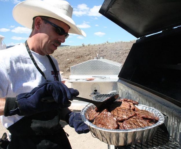 Kurt dishes up hamburgers. Photo by Dawn Ballou, Pinedale Online.